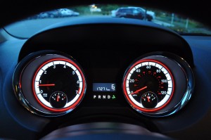 The legible instrument cluster is beautifully backlit in Dodge's white and red motif.